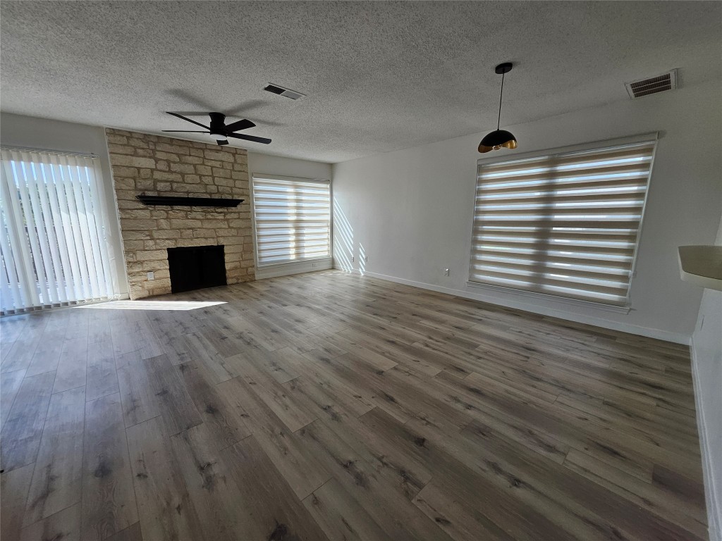 6806 Old Quarry Lane Austin, TX 78731 - Photo 14 of 29 a view of empty room with wooden floor and fireplace
