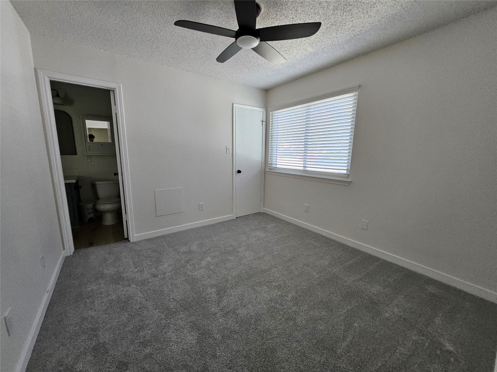 6806 Old Quarry Lane Austin, TX 78731 - Photo 19 of 29 an empty room with a ceiling fan and windows