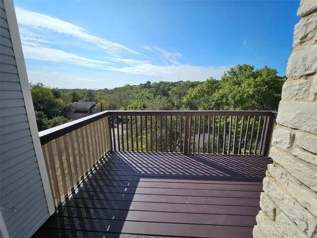 a view of balcony with wooden floor and fence