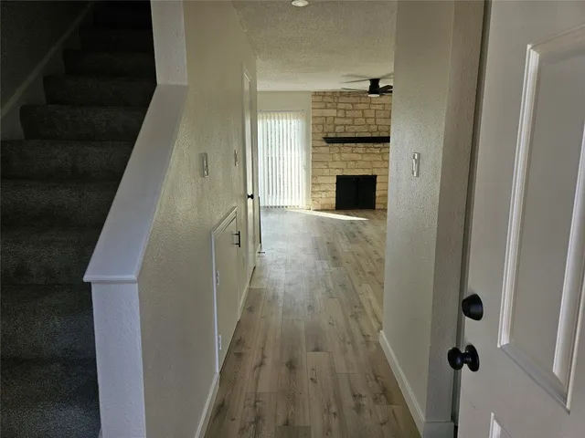 a view of a hallway with wooden floor and staircase