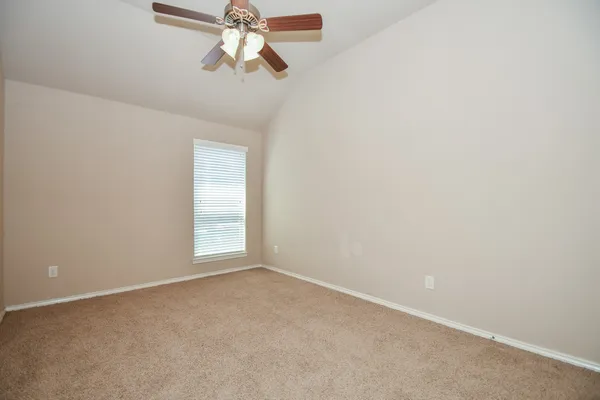 an empty room with a chandelier fan and a ceiling fan