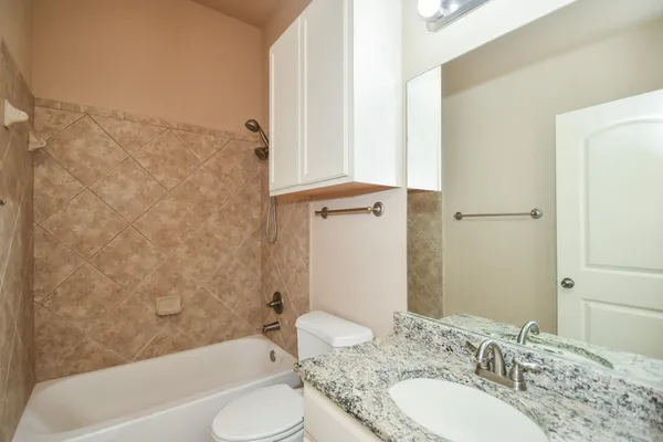 an empty room with chandelier fan and windows