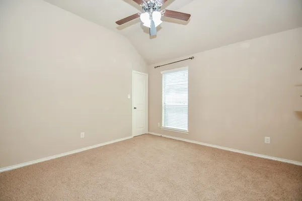 an empty room with chandelier fan