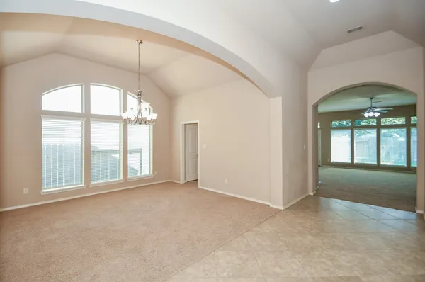 an empty room with windows and chandelier