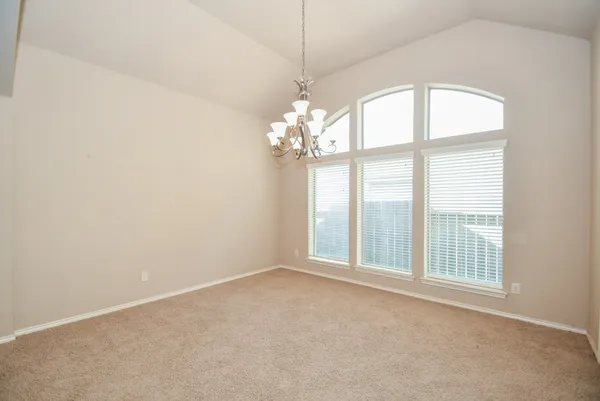 an empty room with windows and chandelier