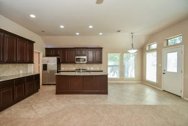 a large kitchen with stainless steel appliances granite countertop a stove and a sink