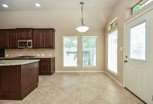 a large kitchen with kitchen island granite countertop a stove a sink and a granite counter top