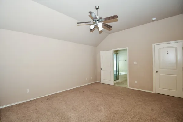 an empty room with closet and fan