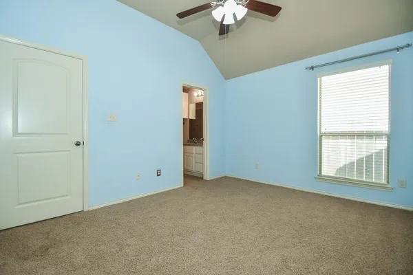 a view of an empty room with a chandelier fan