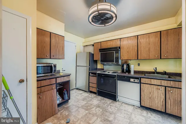 a kitchen with stainless steel appliances granite countertop a stove top oven a sink dishwasher and a microwave oven on the wall