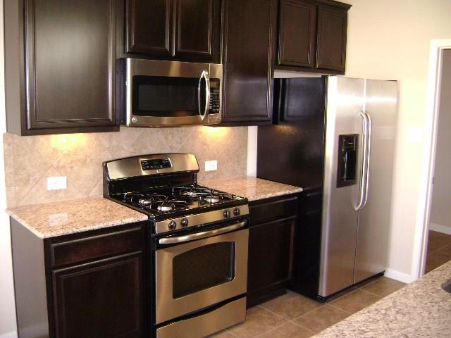 8513 Inca Dove Drive, Unit 363 Austin, TX 78729 - Photo 5 of 15 a kitchen with stainless steel appliances granite countertop a stove microwave and refrigerator