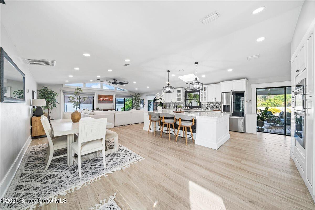 470 Rio Vista Lane Merritt Island, FL 32952 - Photo 19 of 54 a living room with furniture a wooden floor and kitchen view