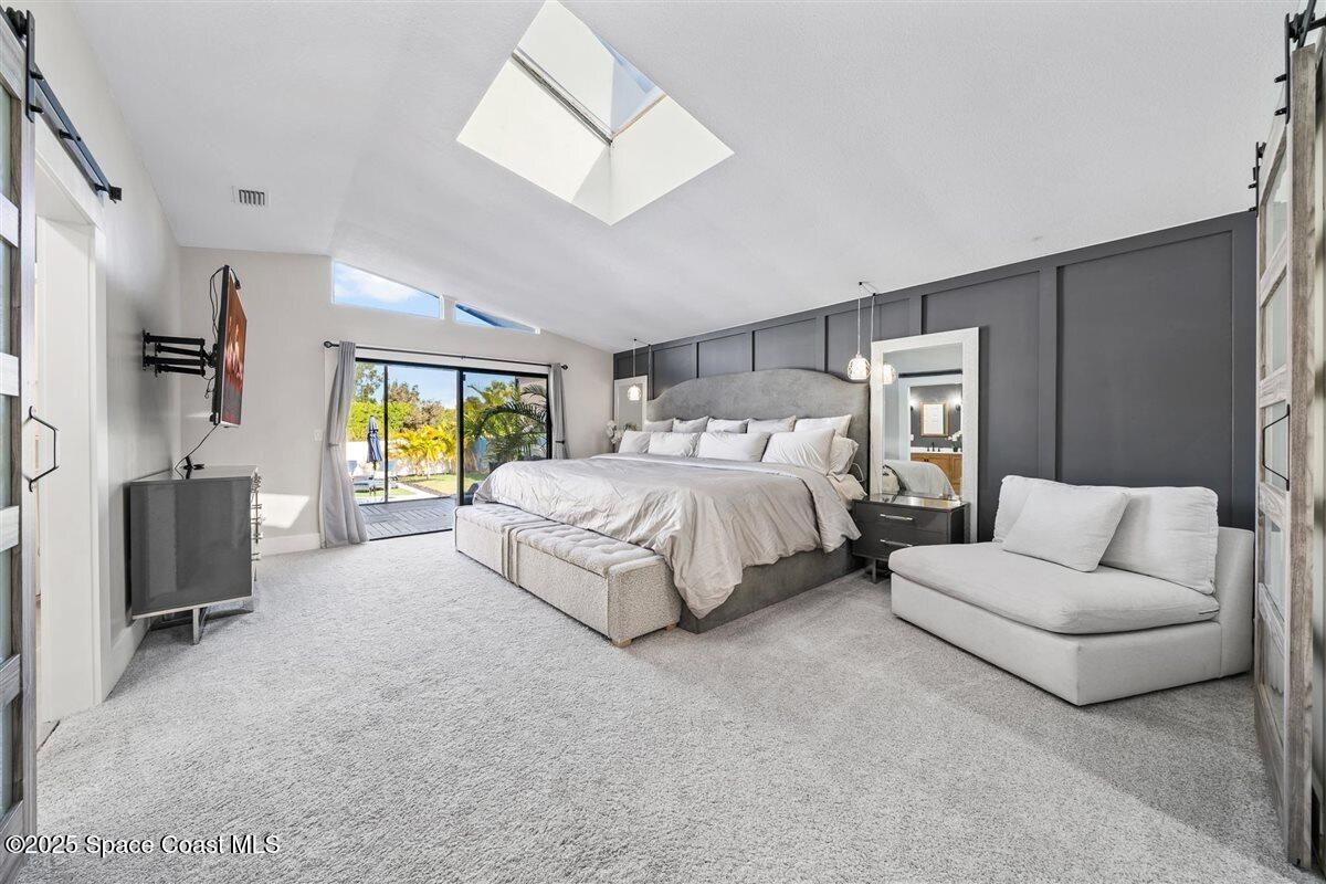 470 Rio Vista Lane Merritt Island, FL 32952 - Photo 22 of 54 a spacious bedroom with a bed and a couch