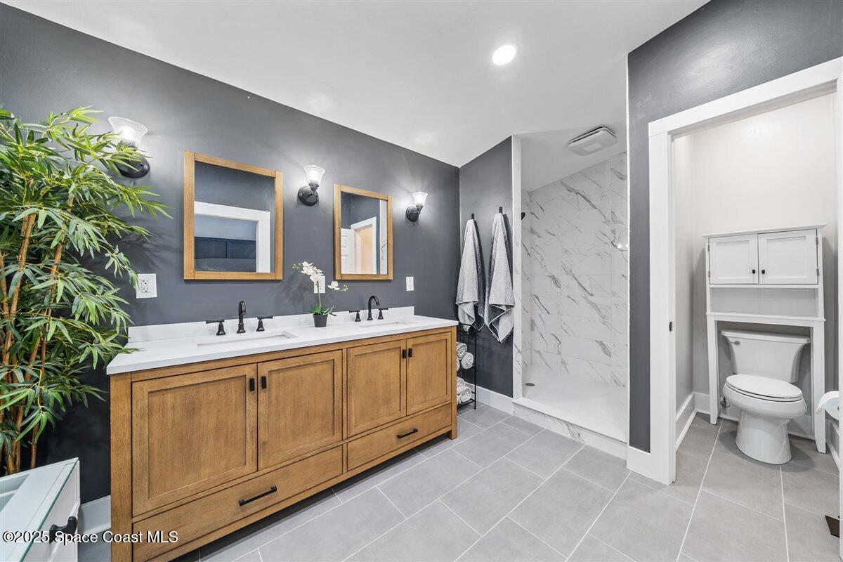 470 Rio Vista Lane Merritt Island, FL 32952 - Photo 25 of 54 a bathroom with a double vanity sink toilet and shower