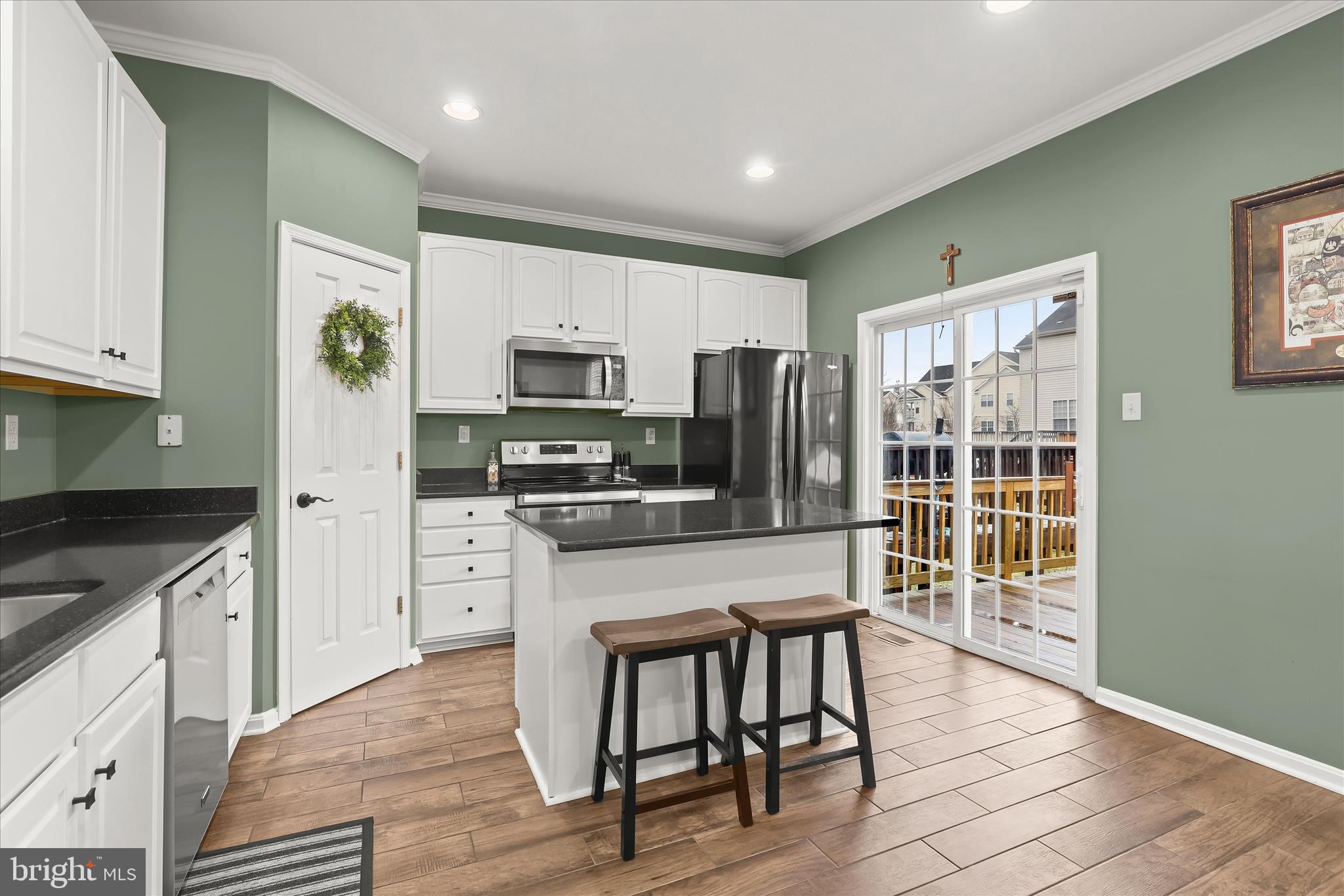 1055 Lily Way Odenton, MD 21113 - Photo 8 of 56 a kitchen with stainless steel appliances granite countertop a stove top oven a sink dishwasher a refrigerator and a dining table with wooden cabinet