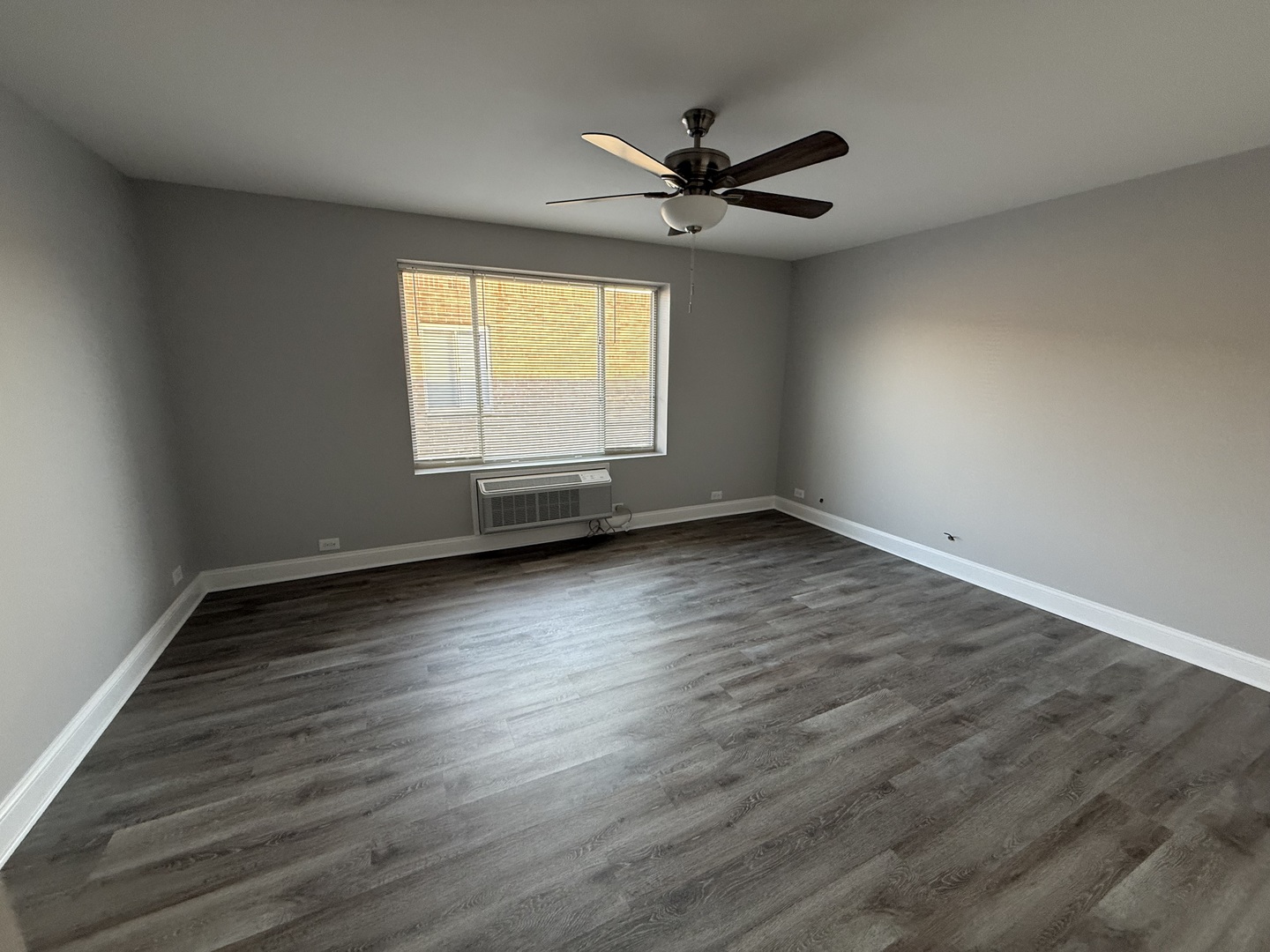 744 West Gordon Terrace, Unit 310 Chicago, IL 60613 - Photo 6 of 8 an empty room with wooden floor fan and windows