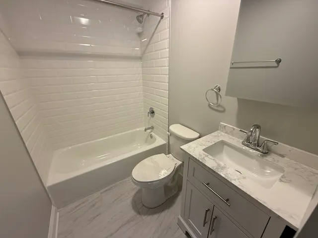a bathroom with a granite countertop sink toilet and shower
