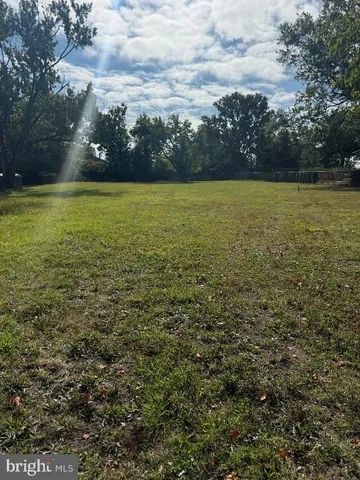 a view of a large pool with lawn chairs under an umbrella