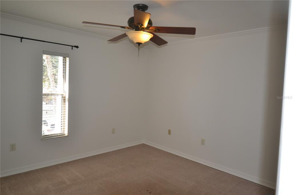 718 Lyndhurst Street, Unit 922 Dunedin, FL 34698 - Photo 25 of 39 an empty room with window and chandelier fan