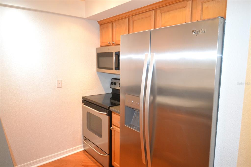 718 Lyndhurst Street, Unit 922 Dunedin, FL 34698 - Photo 3 of 39 a kitchen with metallic refrigerator freezer and a dishwasher