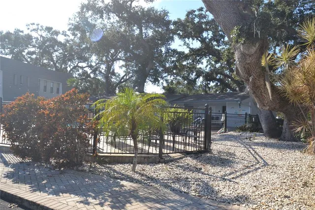 a view of house with outdoor space and trees in the background