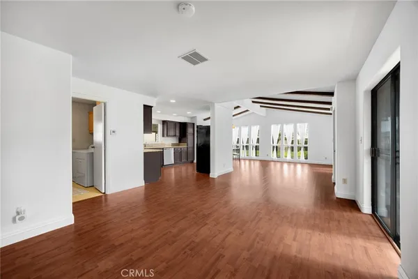 a view of a kitchen with a fridge and wooden floor