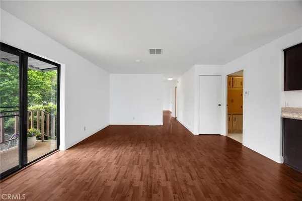a view of a big room with wooden floor and windows