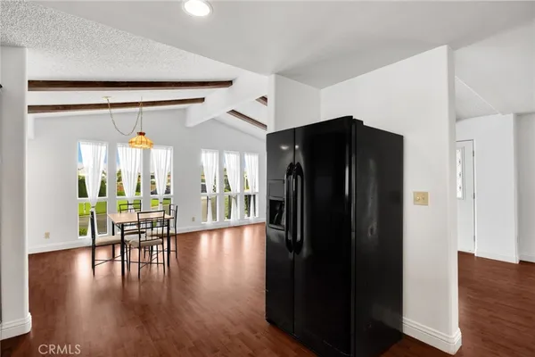 a view of a hallway with wooden floor windows and a dining room
