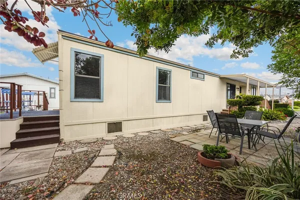 a backyard of a house with yard table and chairs