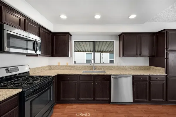 a kitchen with stainless steel appliances granite countertop a stove sink and microwave