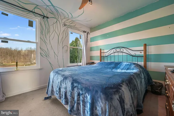 a bedroom with a bed next to a window