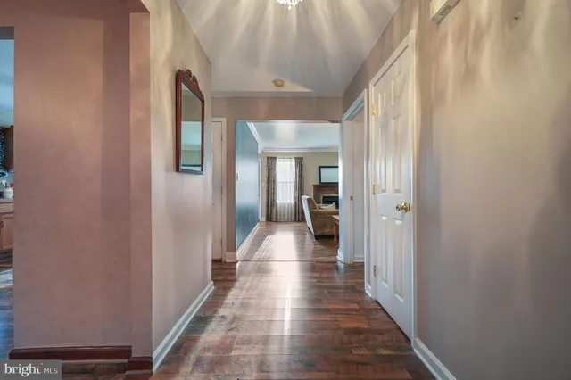 a view of a hallway with a livingroom and a bathroom with sink