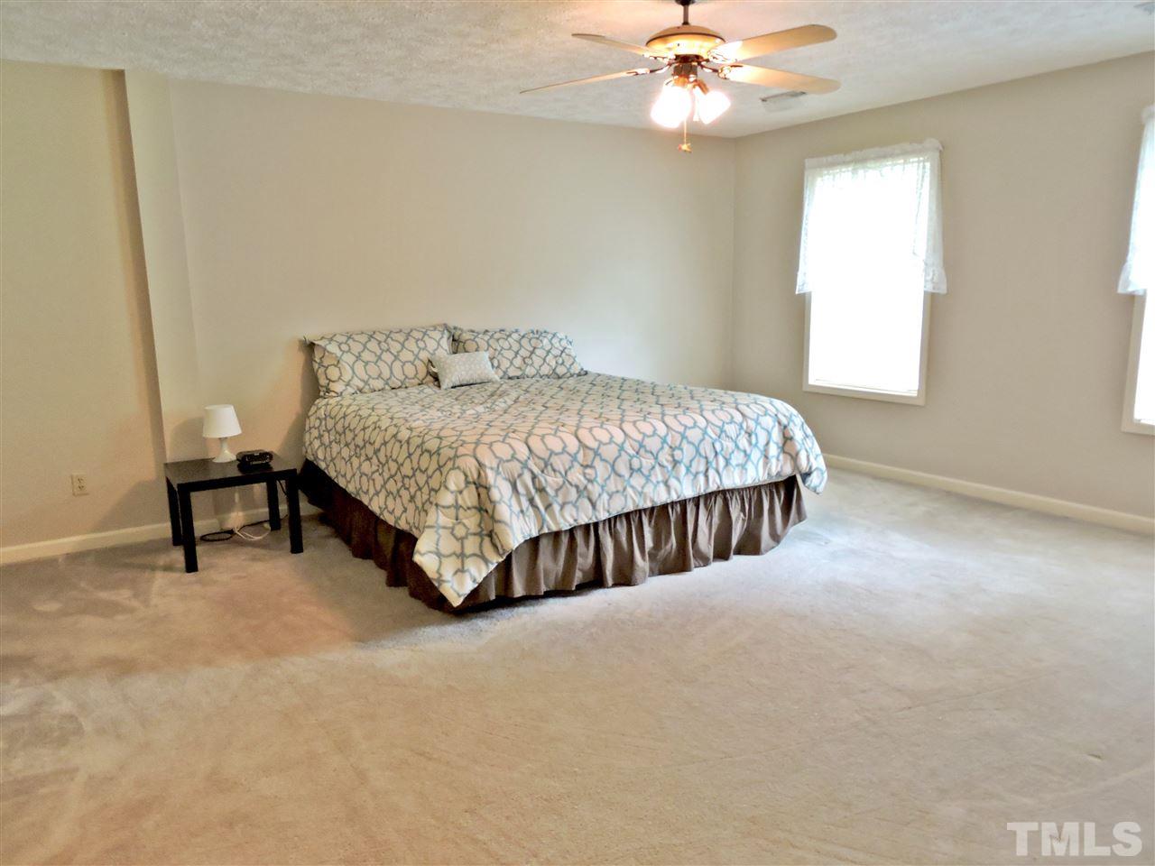 21 Landmark North Roxboro, NC 27574 - Photo 16 of 25 a spacious bedroom with a bed and a chandelier