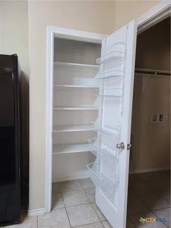 a view of walk in closet with empty racks