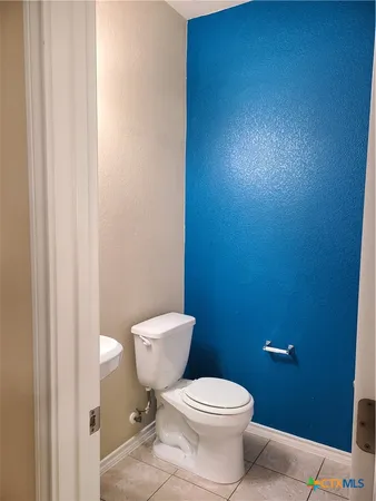 a white toilet sitting next to a white wall