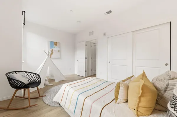 a bedroom with a bed window and a chair