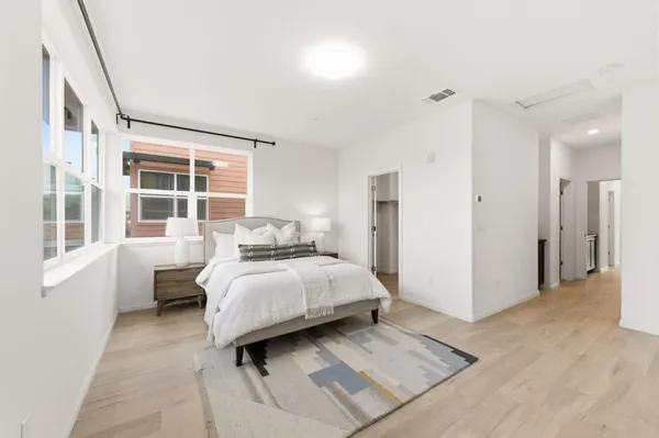 a bedroom with a bed next to a large window
