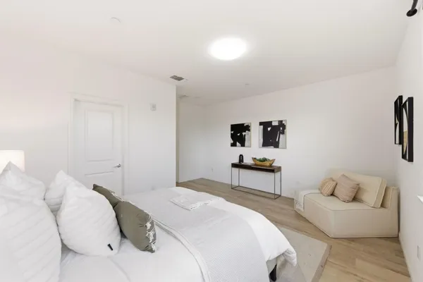 a bedroom with a bed a couch and cabinet