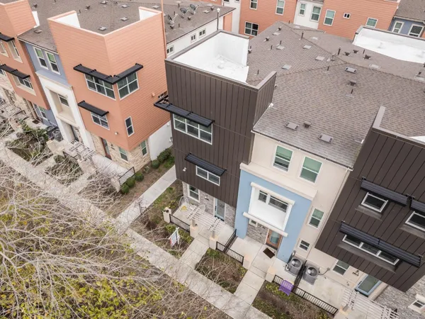 an aerial view of residential houses with outdoor space and trees