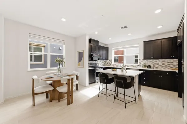 a large kitchen with kitchen island a dining table and chairs