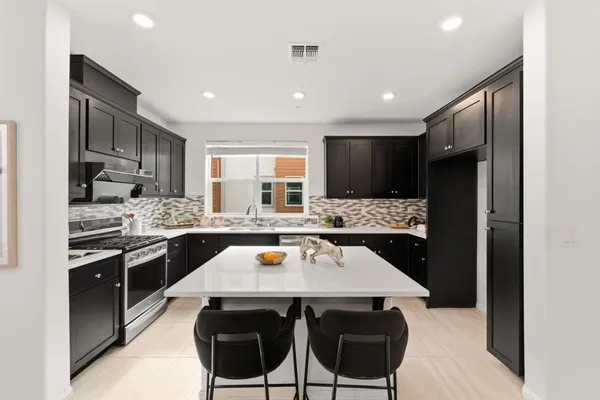 a kitchen with a stove a refrigerator and a dining table