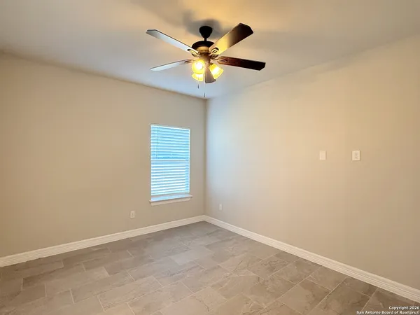 an empty room with window and ceiling fan