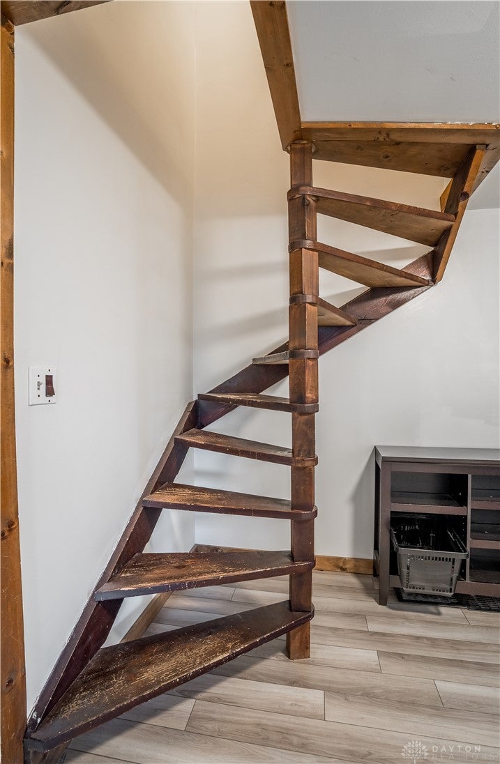 220 Racer Street Troy, OH 45373 - Photo 20 of 33 This unique wooden spiral staircase leads to the primary bedroo and bath, adding character to the living space.