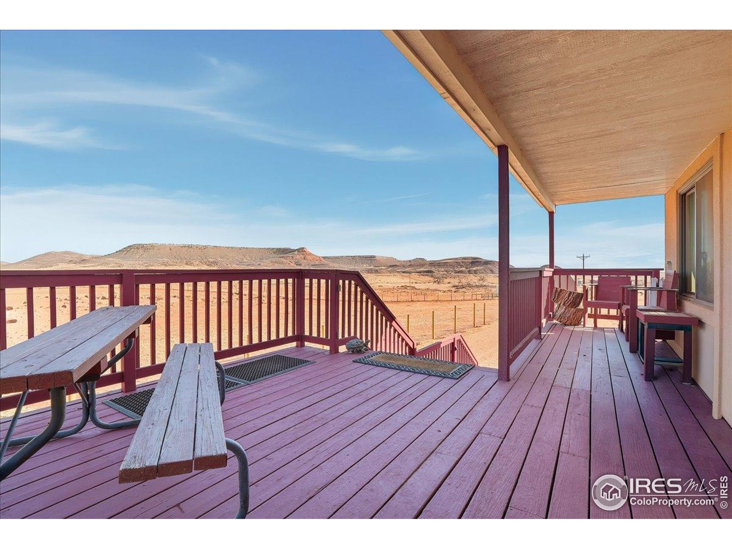 601 Red Mountain Road Livermore, CO 80536 - Photo 33 of 49 a balcony with wooden floor and bench