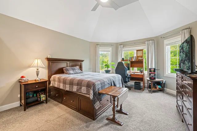a spacious bedroom with a bed and a chandelier