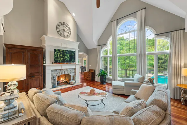 a living room with furniture a fireplace and a floor to ceiling window