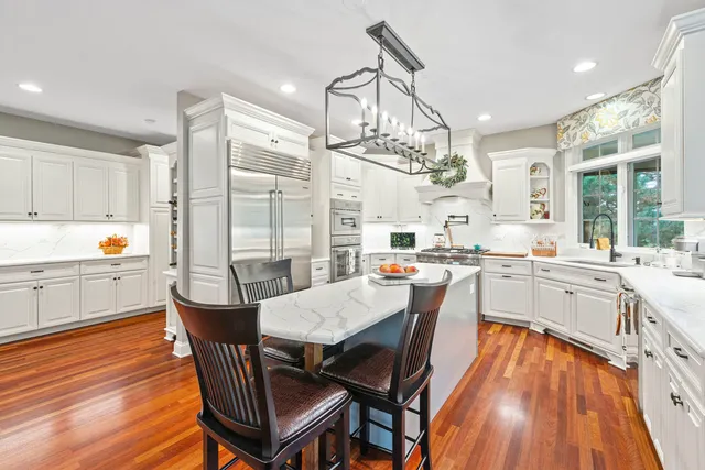 a dining room with stainless steel appliances a table and chairs