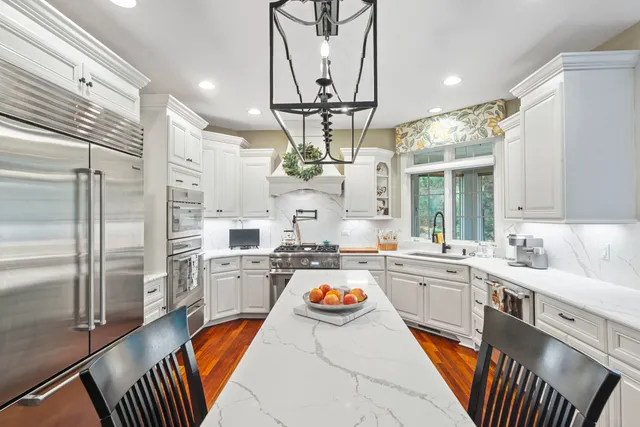 a kitchen with stainless steel appliances granite countertop a sink dishwasher a stove and a refrigerator