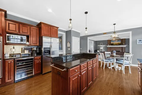 a kitchen with stainless steel appliances granite countertop a stove and a wooden floors