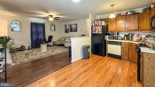 a kitchen with stainless steel appliances granite countertop a refrigerator a stove top oven a sink dishwasher and wooden cabinets